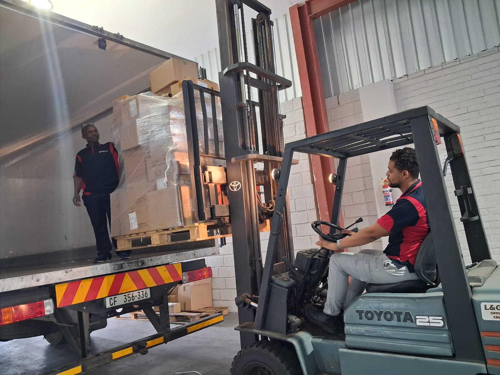 Forklift loading palletised freight into a vehicle